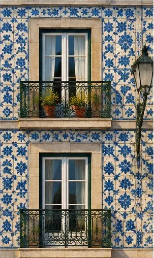 Tegeltableau met portugese tegelgevel: een gevel met blauwe en witte keramische patronen en een smal balkon.
